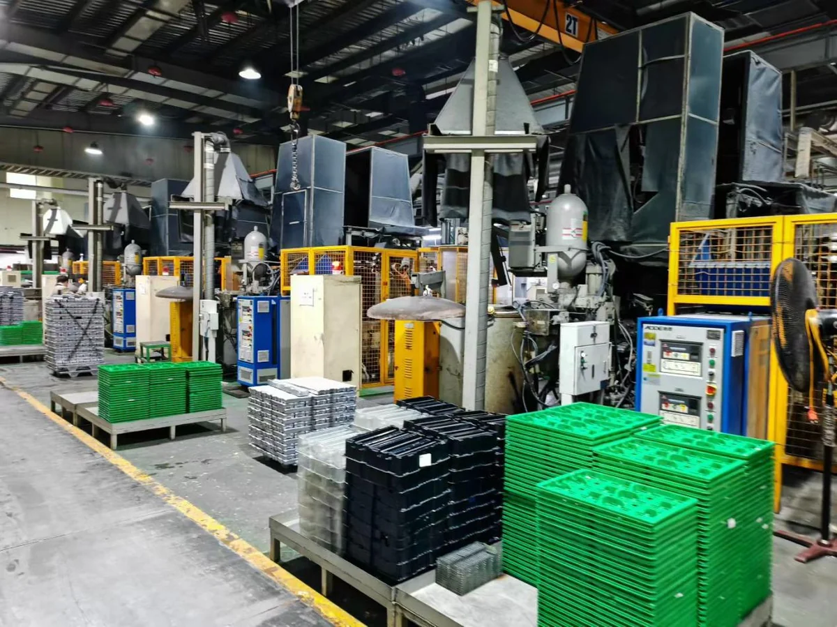 Die casting workshop with multiple die casting machines and temperature controllers producing large automotive components