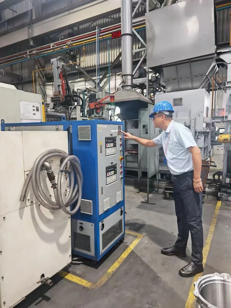 Engineer operating an AODE dual-system high-temperature oil temperature controller for large die casting molds